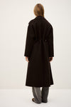 Person wearing a long black coat on a white background rear view