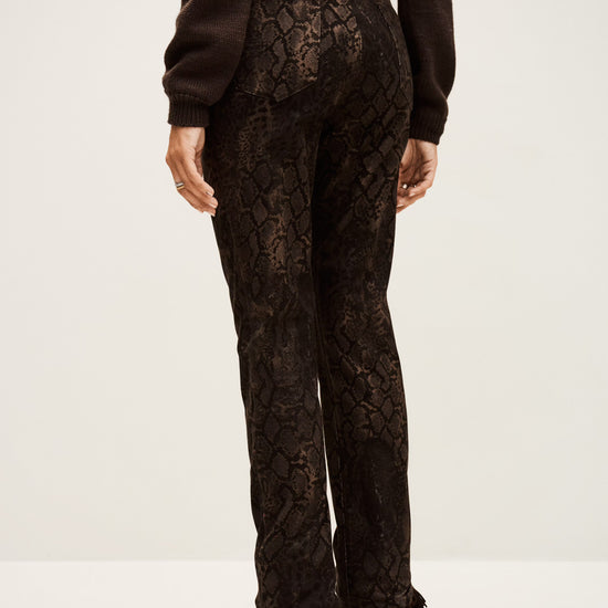 Person wearing black snake print pants on a white background