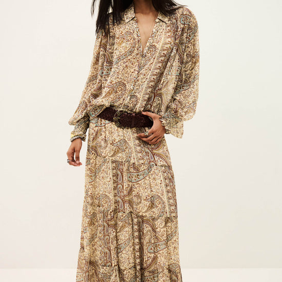 woman wearing matching paisley shirt and  skirt on white background