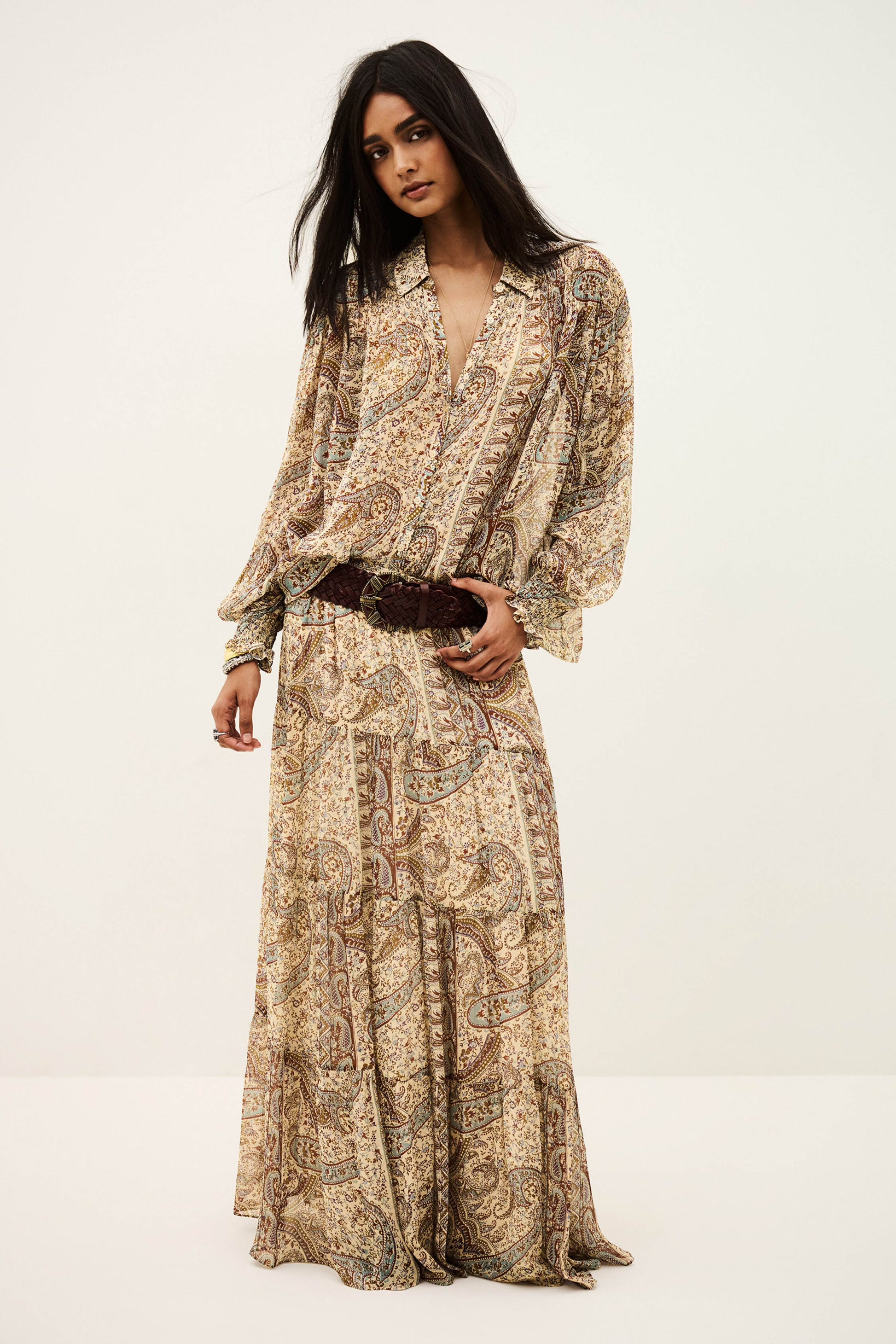 woman wearing matching paisley shirt and  skirt on white background