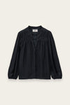 A black long-sleeve blouse with a gathered, pleated chest design and a button-down front, displayed flat against a light cream background.