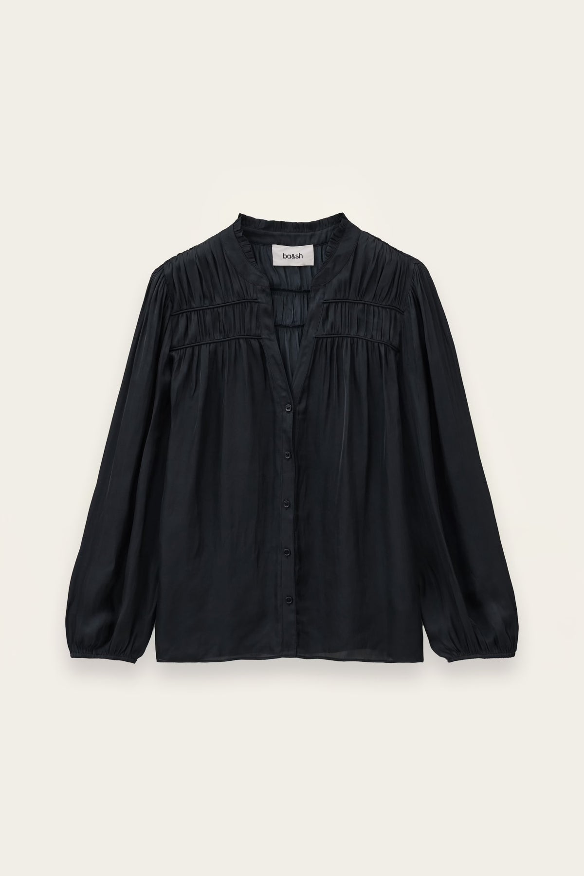 A black long-sleeve blouse with a gathered, pleated chest design and a button-down front, displayed flat against a light cream background.