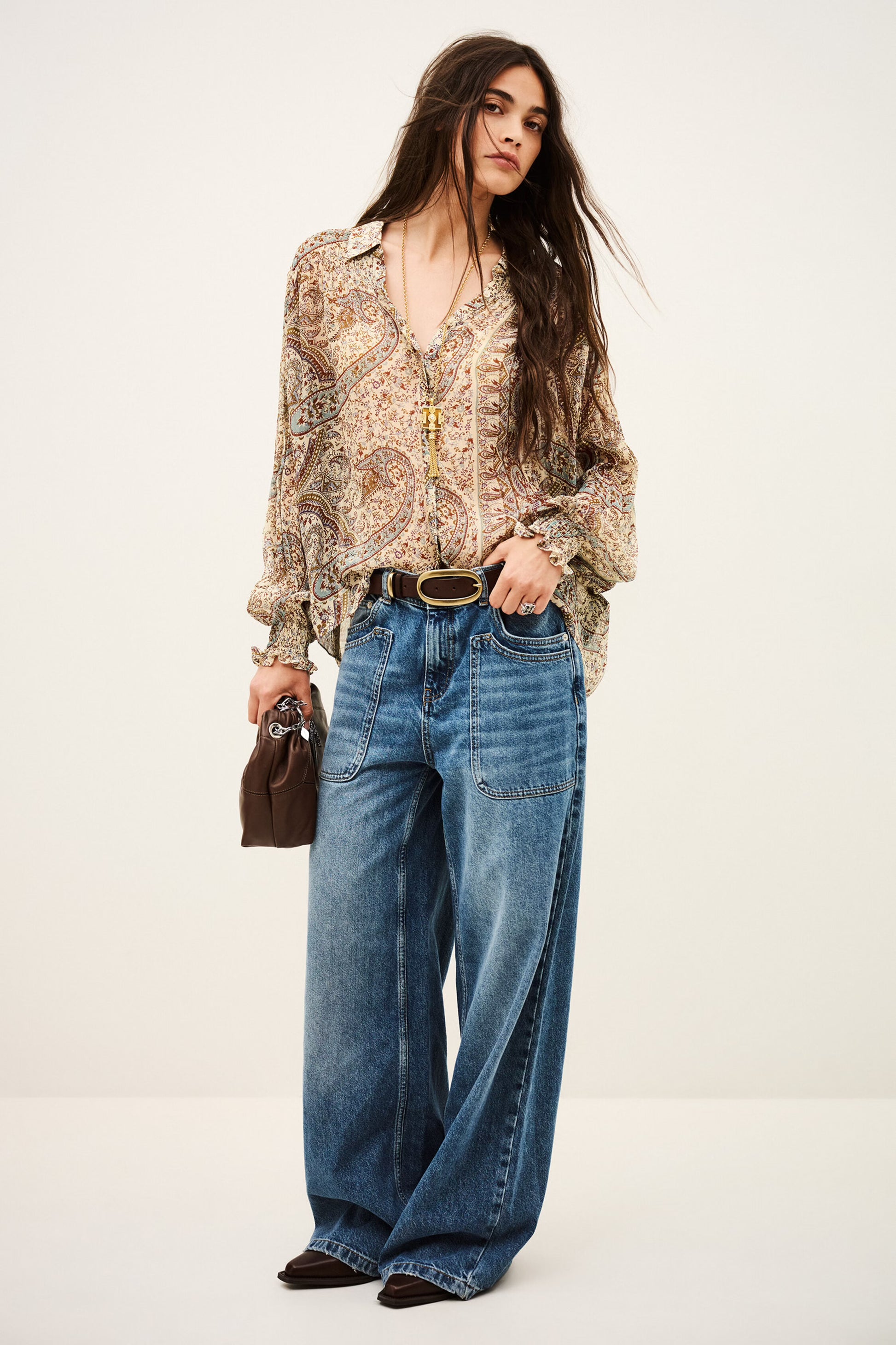 woman wearing paisley blue and brown shirt and jeans on white background full outfit shot