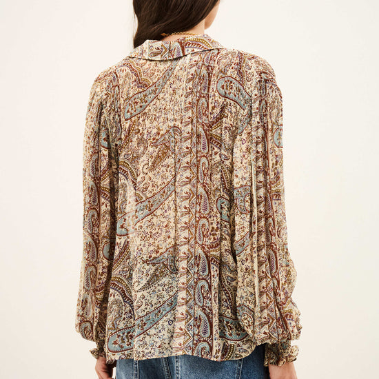woman wearing paisley blue and brown shirt and jeans on white background rear view