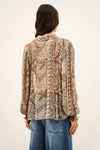woman wearing paisley blue and brown shirt and jeans on white background rear view
