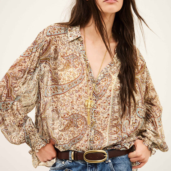 woman wearing paisley blue and brown shirt and jeans on white background