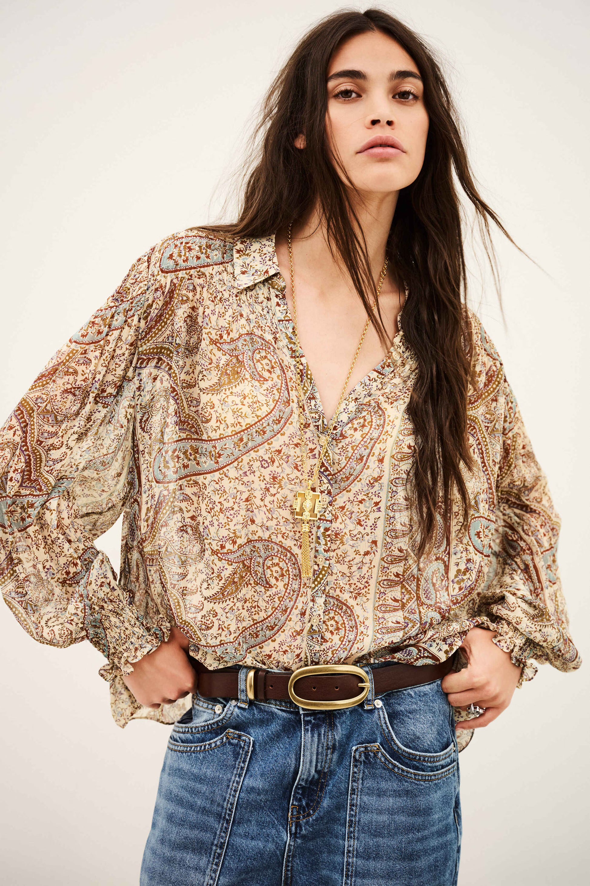 woman wearing paisley blue and brown shirt and jeans on white background