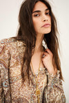 woman wearing paisley blue and brown shirt close up on white background