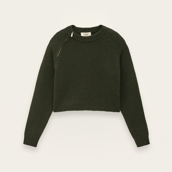 An olive green cropped knit sweater with long sleeves and diagonal shoulder seams, displayed flat against a light off-white background.