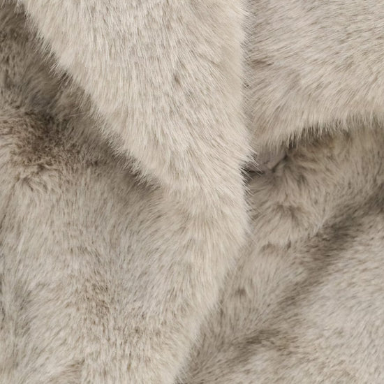 A close-up of plush faux fur fabric in a light warm gray or greige tone, showing the soft texture and layered folds of the material.