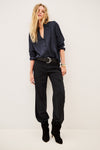 Woman wearing blue shirt and black trousers on white background