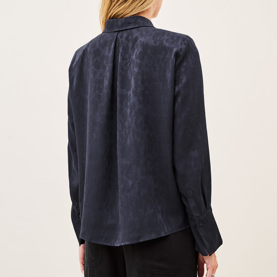 Woman wearing blue shirt and black trousers on white background rear view
