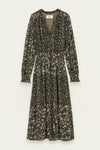 A long-sleeve midi dress with a dark green base and a dense beige and light green floral print, featuring a V-neckline and a gathered waist, shown against a light off-white background.