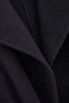 Close-up of a dark charcoal gray or black textured fabric with soft draped folds and a fine woven surface.