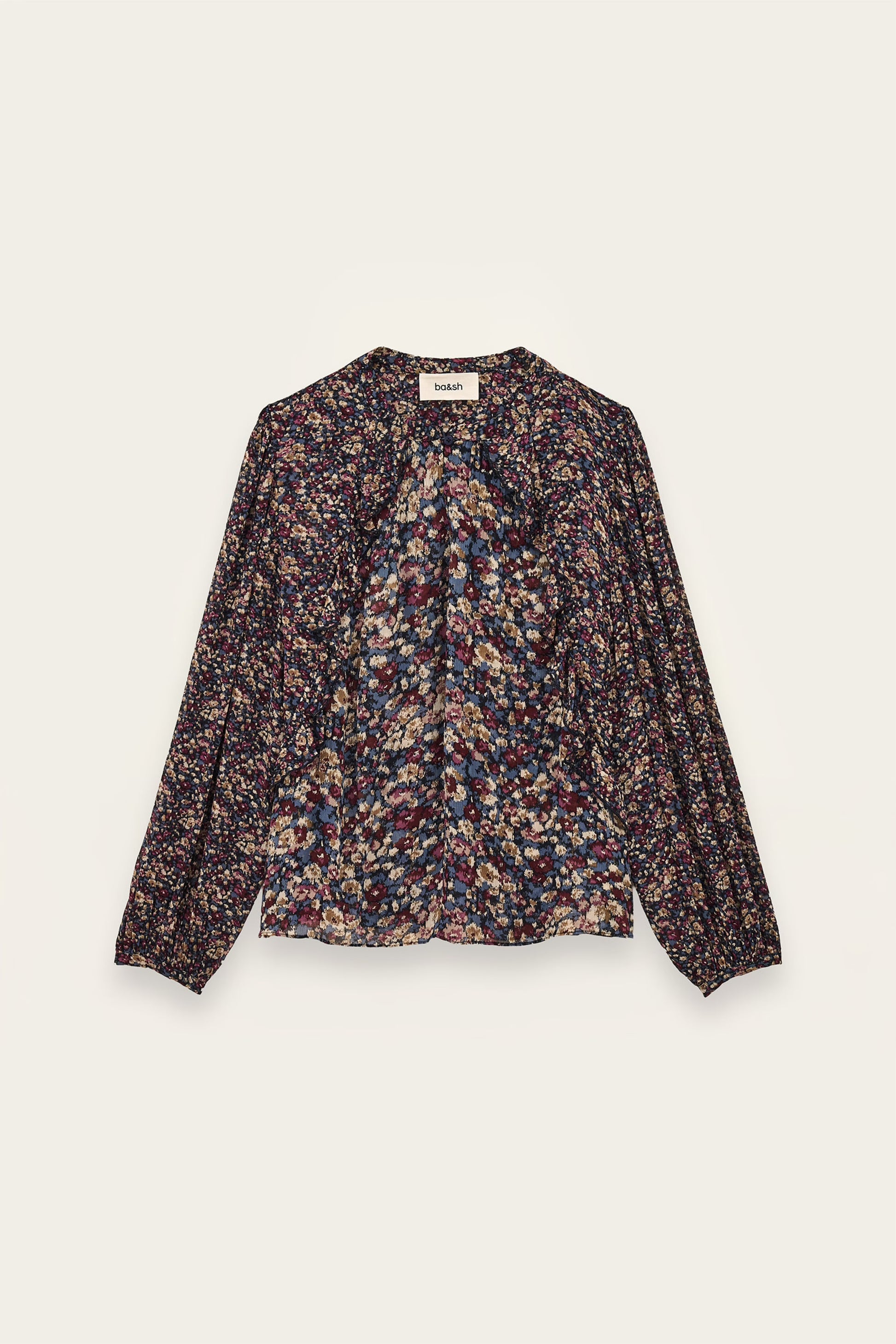 A long-sleeve blouse with a dense multicolor floral and abstract print on a dark base, featuring a gathered front and a round neckline, shown flat against a light cream background.