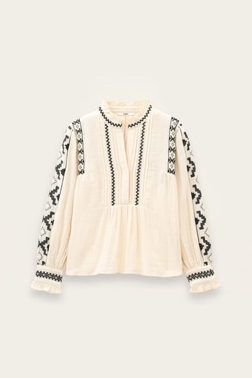 An off-white long-sleeve blouse with black geometric embroidered patterns along the neckline, front placket, and sleeves, displayed flat against a light beige background.