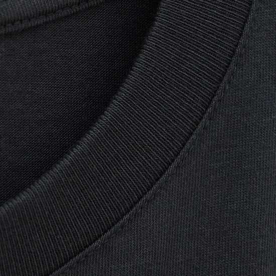Close-up detail of a black crew-neck t-shirt showing the ribbed collar and inner neck lining.