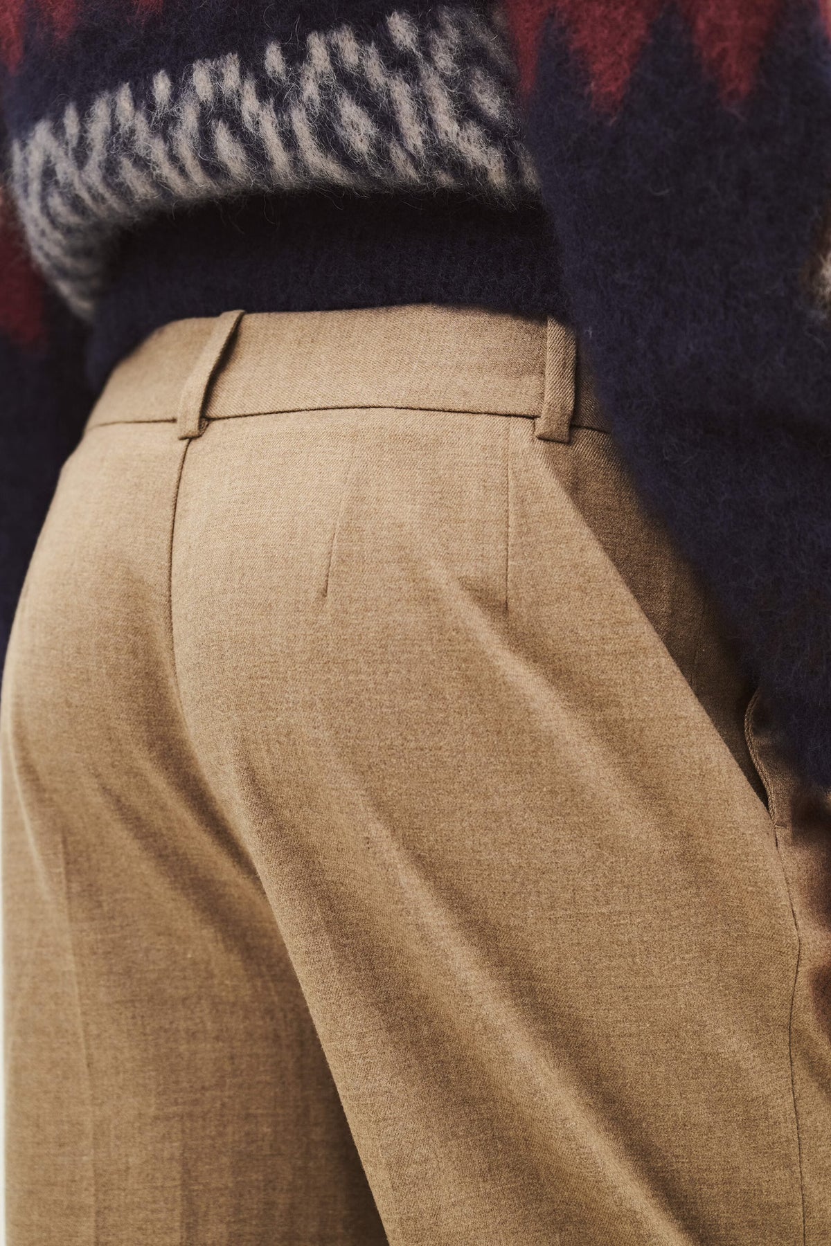 Close up of the rear of a pair of beige trousers