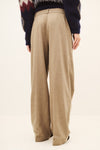 Woman wearing a beige pair of trousers and a jumper rear view