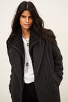 model wearing a grey pinstripe wool coat  and white t shirt 