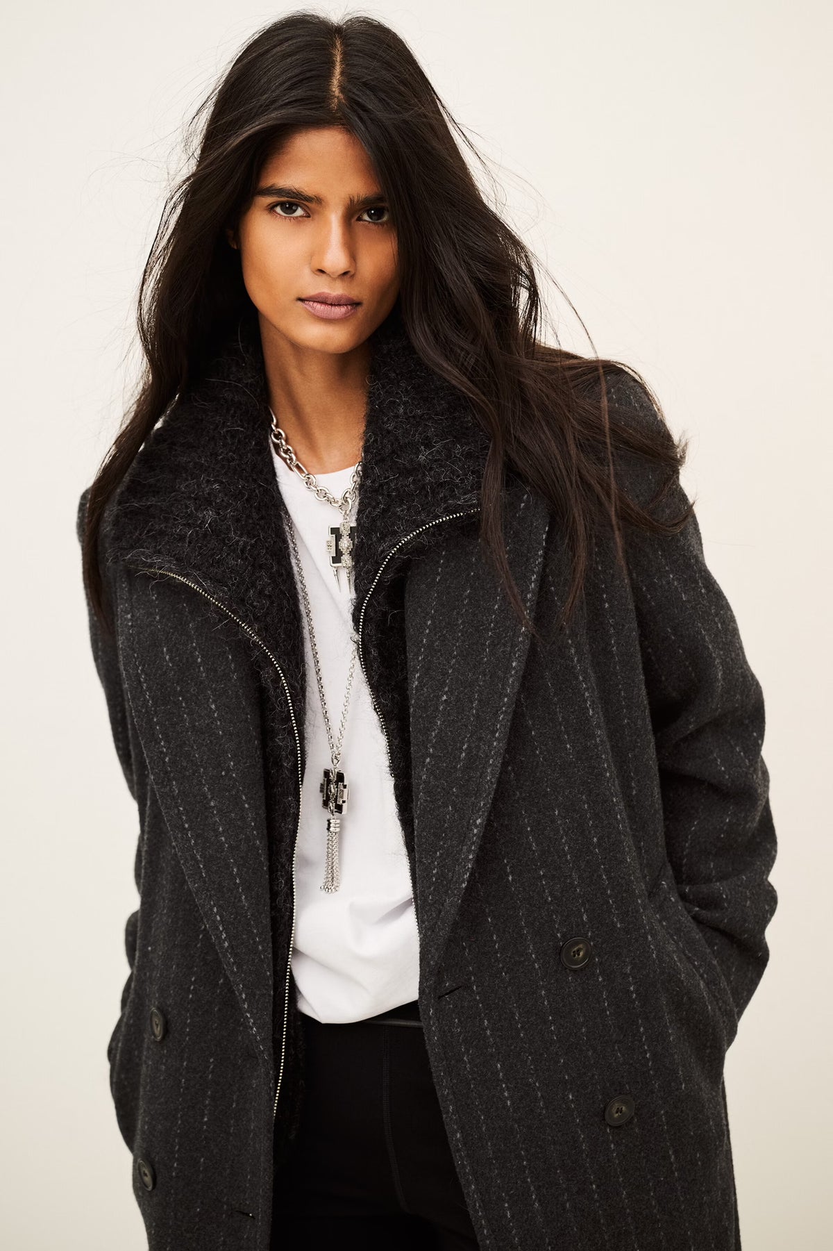 model wearing a grey pinstripe wool coat  and white t shirt 