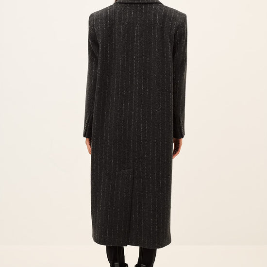 model wearing a grey pinstripe wool coat  rear view