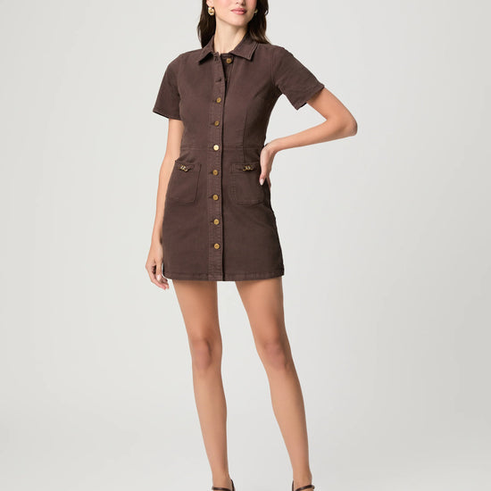 Woman wearing a brown dress with buttons on a white background