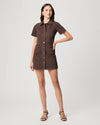 Woman wearing a brown dress with buttons on a white background