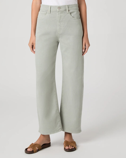 Person wearing light green wide-leg paige jeans on a white background