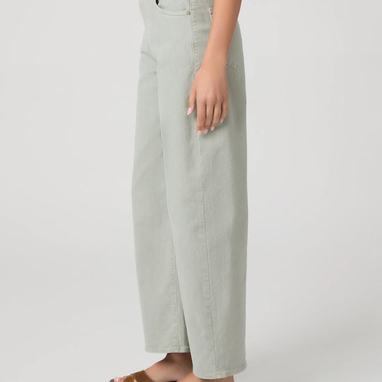 Person wearing light green wide-leg paige jeans on a white background side view