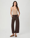 A woman modeling a beige ribbed tank top and dark brown wide-leg cropped pants with a drawstring waist, paired with brown slide sandals, against a light gray studio background.