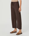 A model wearing dark brown wide-leg cropped pants with a drawstring waistband, paired with brown slide sandals, against a light gray studio background.