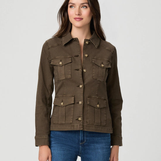 A woman modeling a dark brown utility jacket with four front flap pockets and button closures, paired with blue jeans, against a light gray studio background.