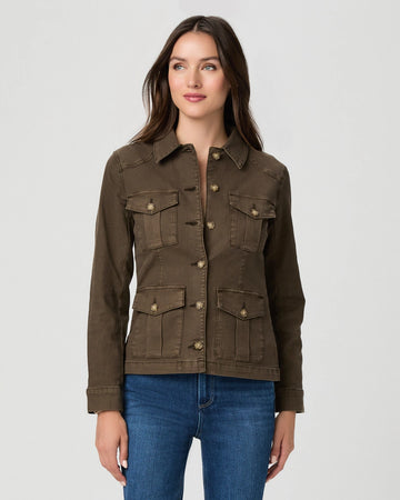 A woman modeling a dark brown utility jacket with four front flap pockets and button closures, paired with blue jeans, against a light gray studio background.