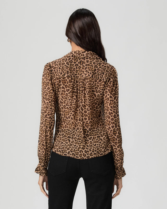 Rear view woman wearing a leopard print blouse against a plain background