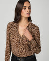 Woman wearing a leopard print blouse against a plain background