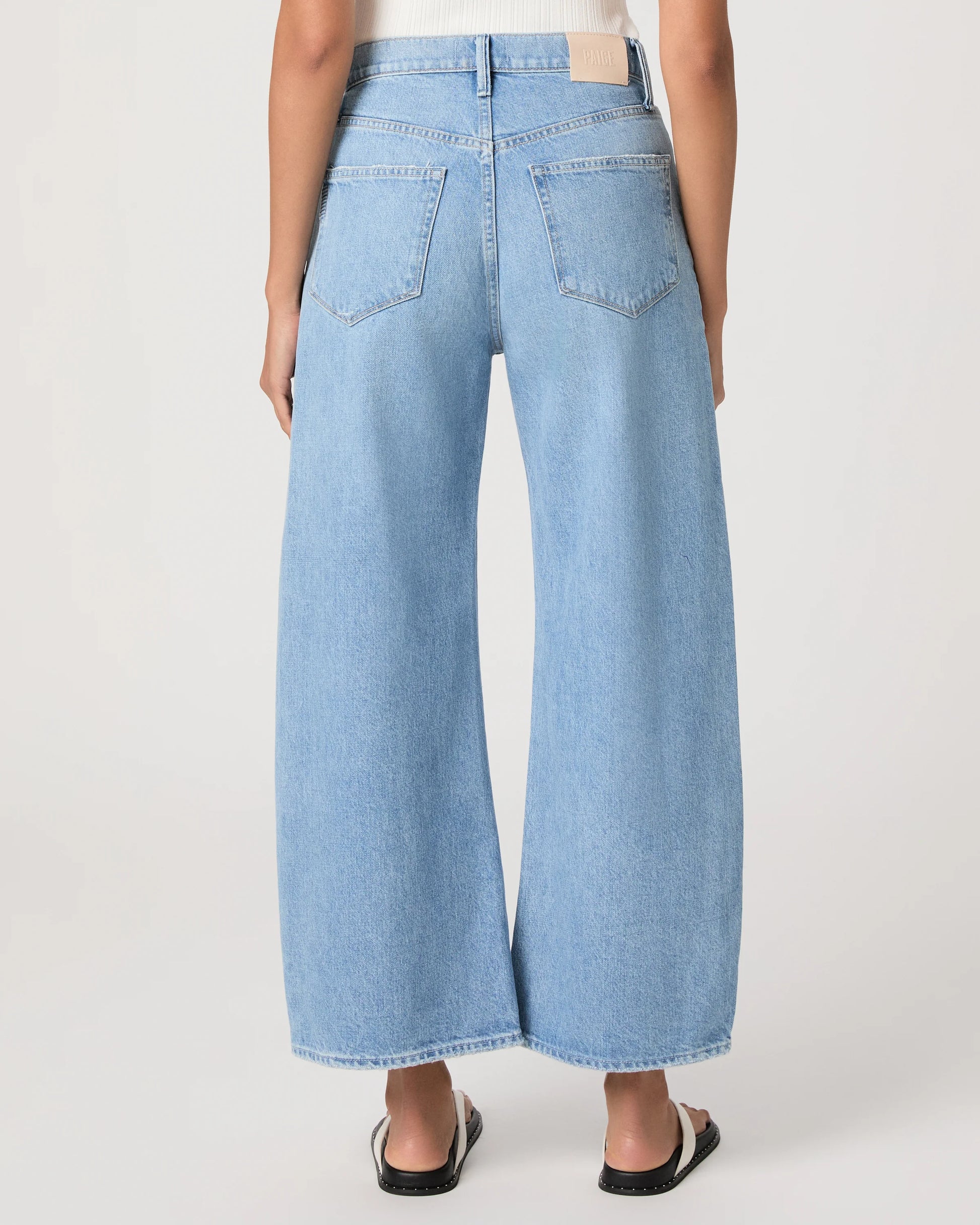 Light blue barrel-leg jeans worn by a person on a white background