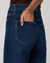 Person wearing blue jeans with a neutral background