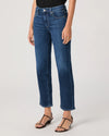 Person wearing blue jeans by paige on a plain background side view
