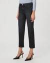 A model wearing a pair of dark charcoal gray cropped jeans with a straight-leg fit, paired with black slingback heels and a light blue striped top, shown against a plain light gray studio background.