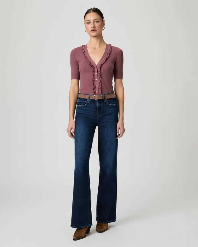 Woman wearing a maroon top and blue jeans on a white background from Paige