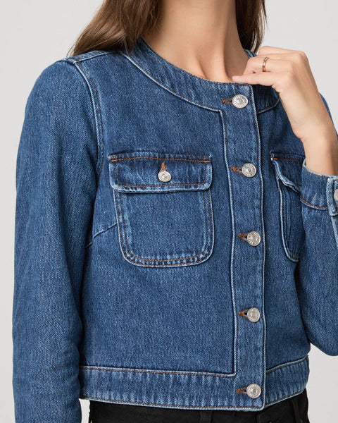 round neck dark blue denim jacket with silver buttons, 2 flap buttoned pockets and cropped fit close up
