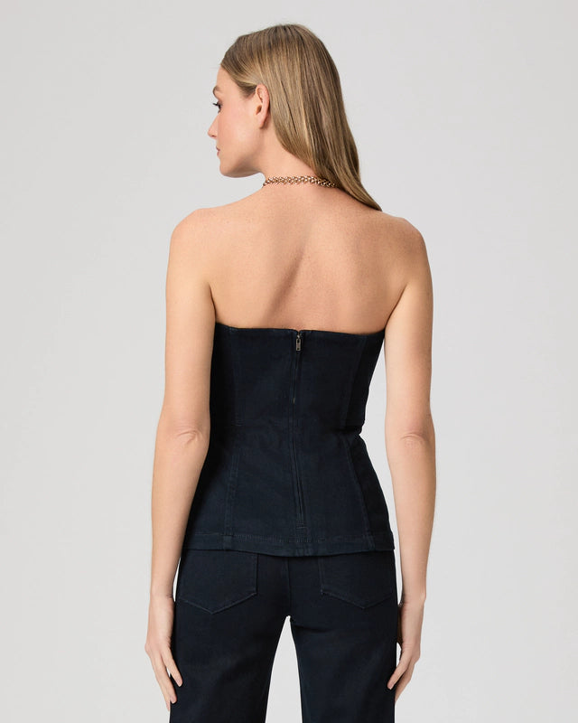 Woman wearing a denim strapless top and pants on a plain background rear view