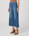 person wearing blue paige jeans on a white background side view