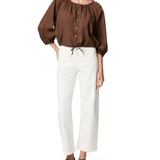 woman wearing white jeans and brown top on white background 