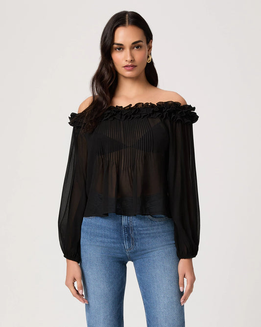 Woman wearing a black off-shoulder top and blue jeans on a light gray background