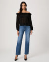 Woman wearing a black off-shoulder top and blue jeans on a white background