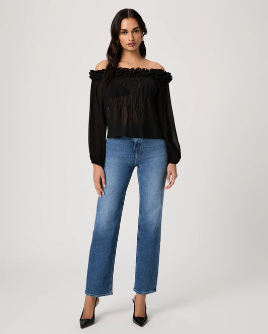 Woman wearing a black off-shoulder top and blue jeans on a white background