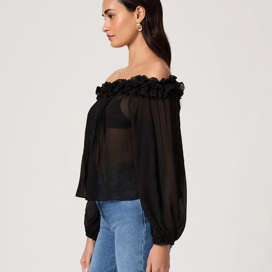 Woman wearing a black off-shoulder top with floral details on a white background