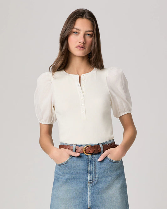 Woman wearing a white blouse and blue jeans on a plain background